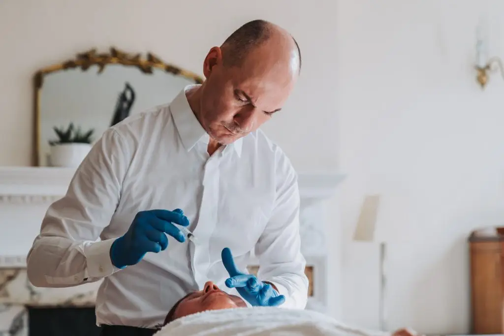 Dr John Tsagaris administering acupuncture treatment in a Harley Street clinic setting